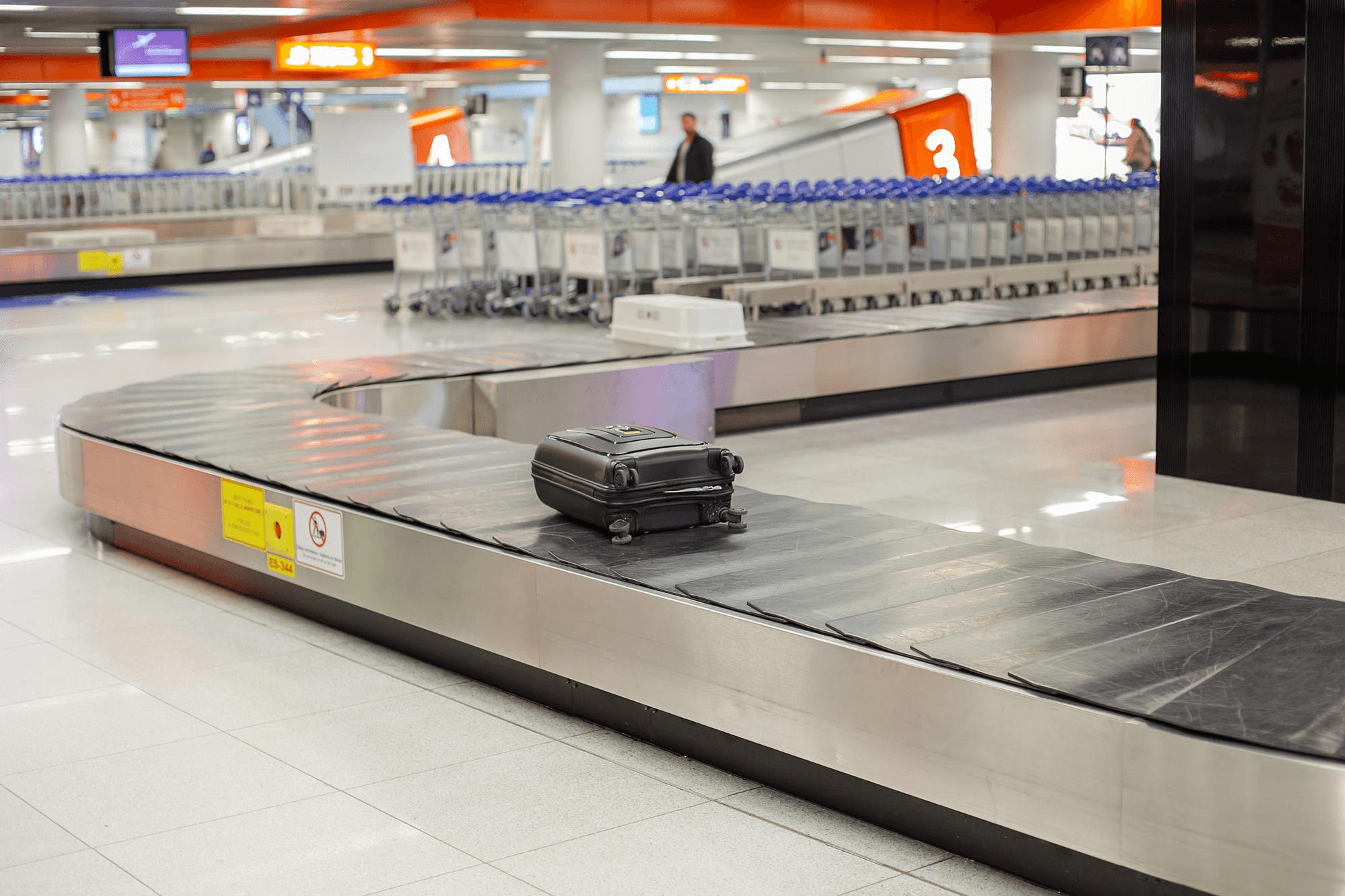 Single suitcase on airport conveyor belt.