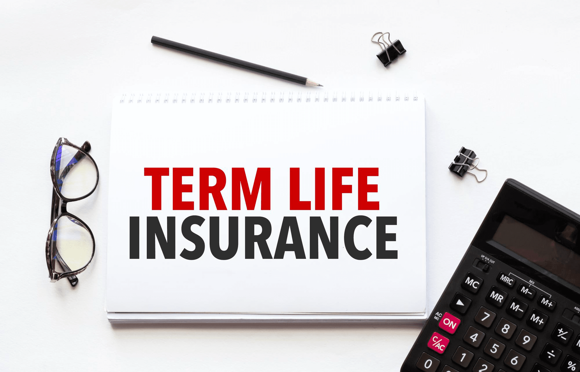 Term life insurance written on paper with calculator.
